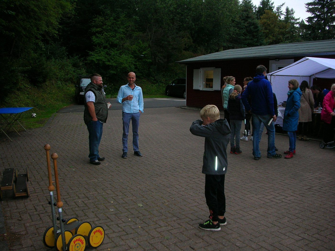 Besucher und Kinder auf dem Platz, vorn warten Pedalos und Balancier-Spiele