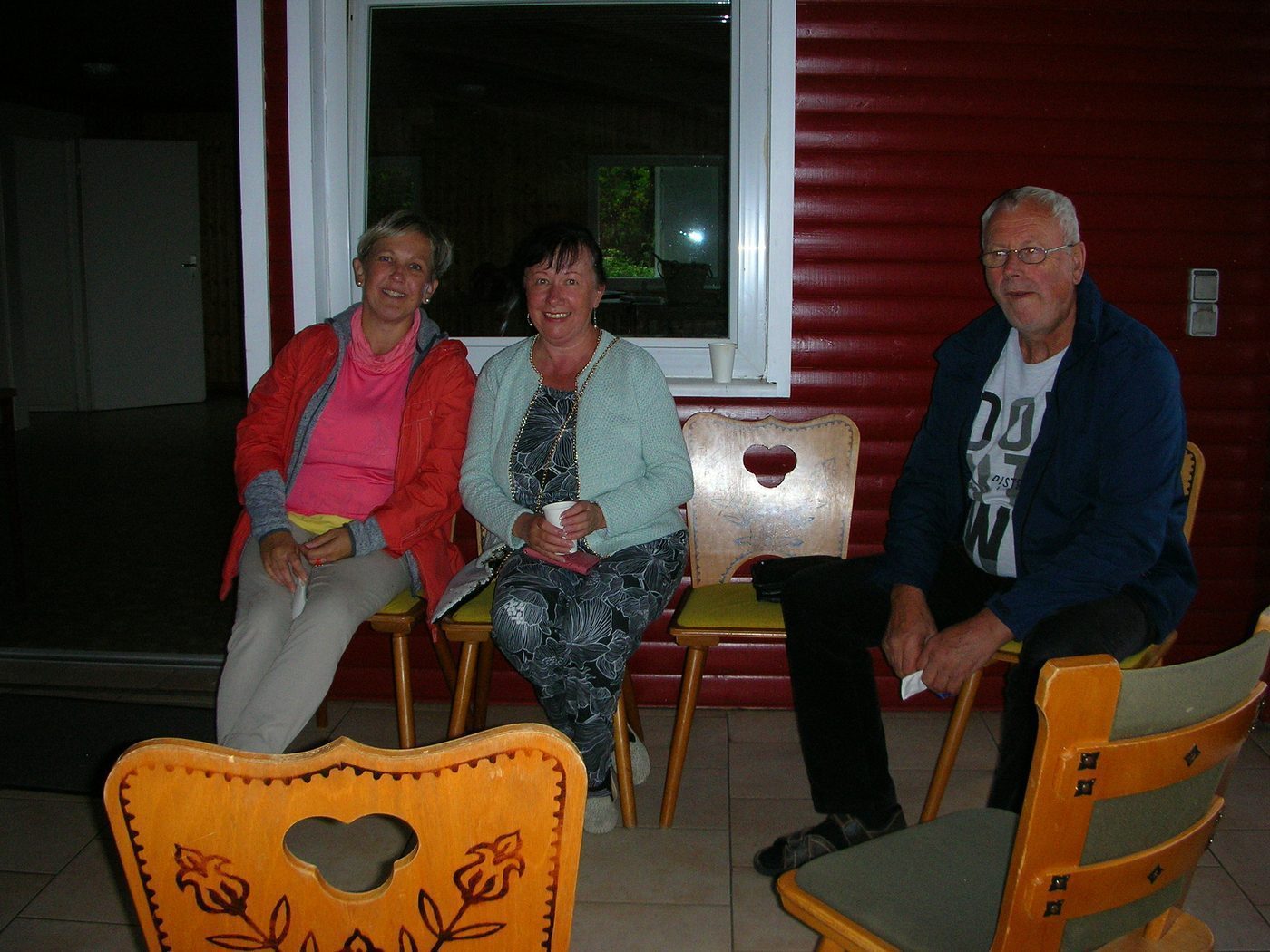 Gemütliche Runde auf der Veranda, mit Becher in der Hand